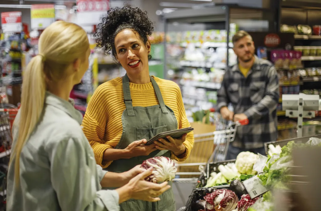 Helpful Grocery Store Worker Assisting Customer